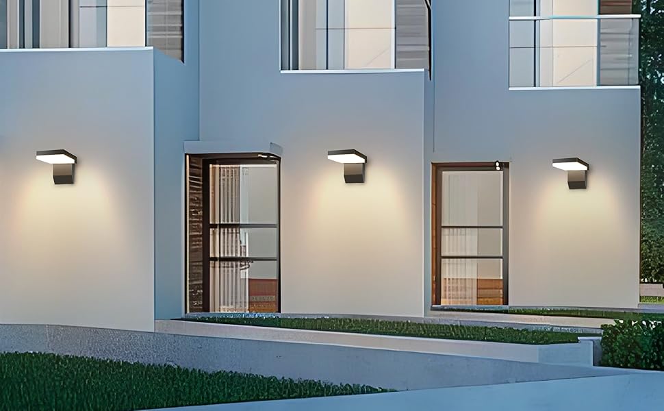 Extérieur de maison de ville moderne avec appliques murales illuminant les entrées, avec des murs blancs et un design