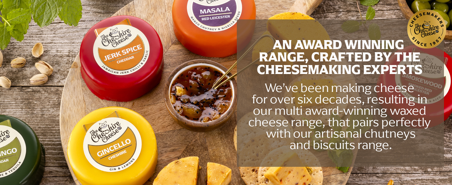 Assortment of round cheese wheels with colorful wax coatings, some cut to show texture. Text mentions award-winning range crafted by cheesemaking experts.
