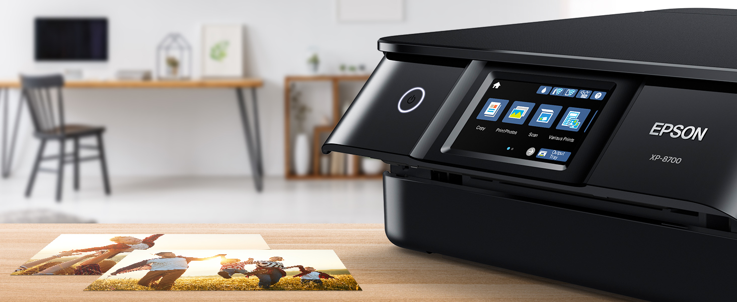 Printer on a table in the foreground with photos next to it