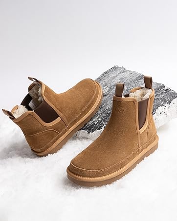 Pair of tan suede Chelsea boots with elastic side panels and grey textile detail at the opening. Boots shown against white background.