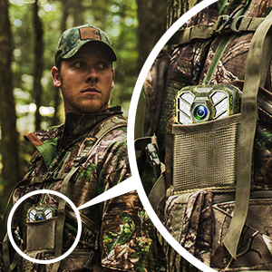Camouflage-patterned tactical gear with a pocket holding a small camera. Close-up view highlights the pocket's design for easy access to equipment.