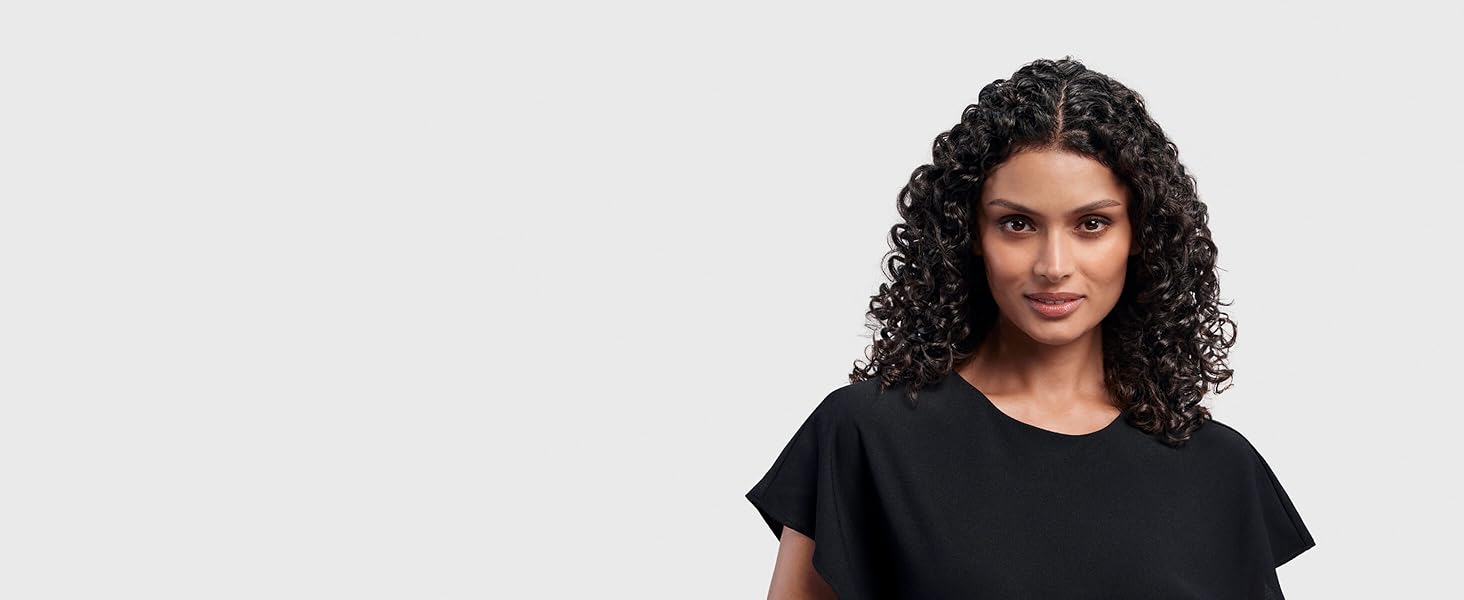 A model with dark hair styled into defined ribbon curls.
