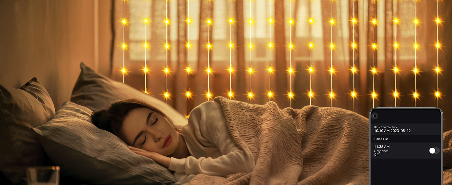 Woman sleeping in bed with warm-toned string lights hanging in background. Digital device on nightstand displays sleep-related information.