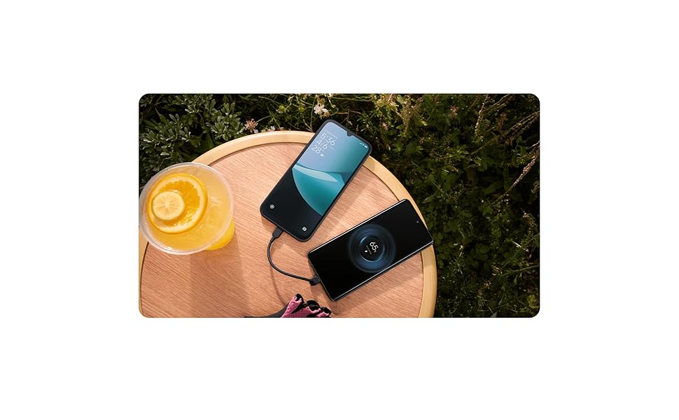 Overhead view of smartphone and wireless earbuds on wooden surface with orange citrus fruit visible.