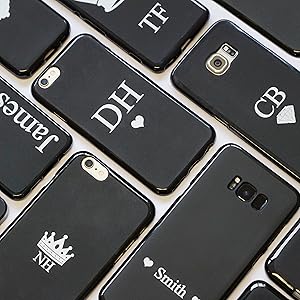 Collection of black smartphone cases with white monogram designs including initials, crowns, and text arranged in a grid pattern.