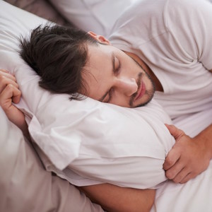 man sleeping soundly on a bed with bamboo bedding sheets and pillow cases