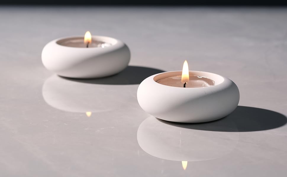 two white ceramic candles on a table