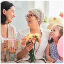 Three generations laughing: woman with gift, grandma with flowers, girl with balloon.