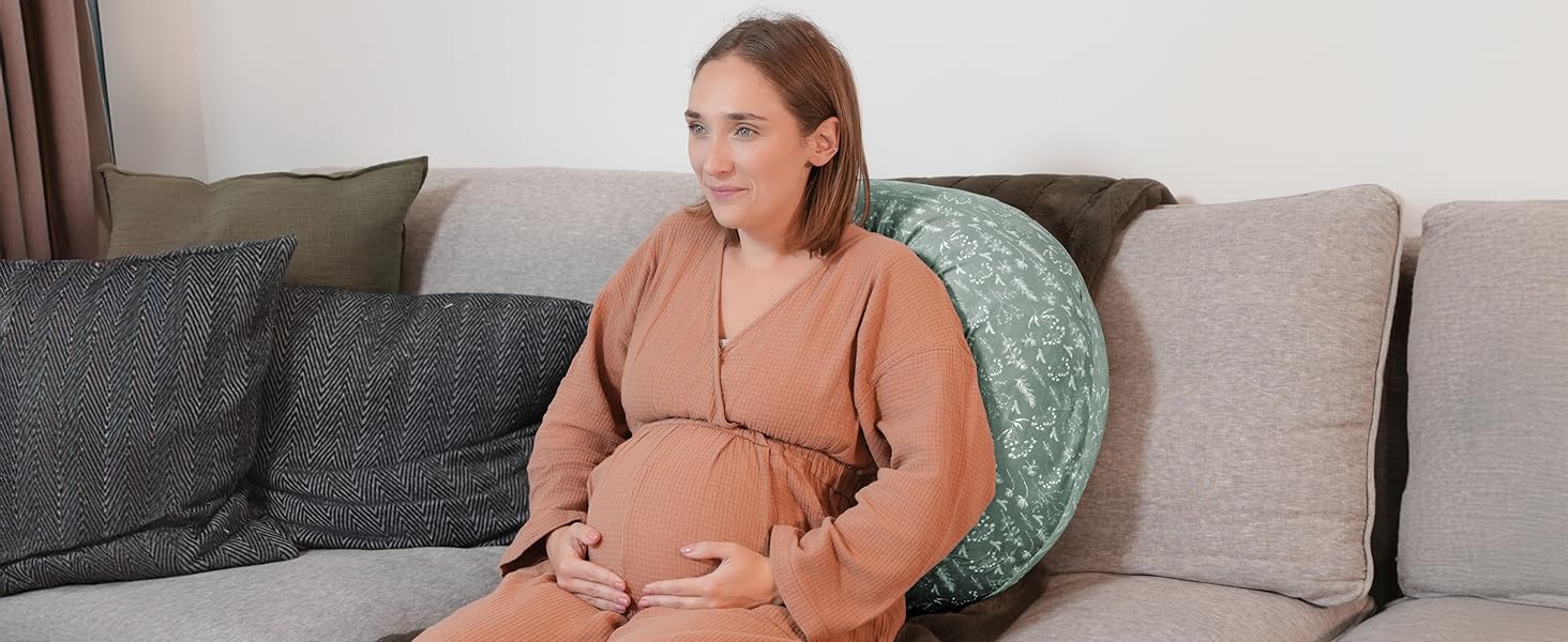 A comfortable living room setting with gray sofa and decorative round cushion, featuring soft textural elements and neutral tones.