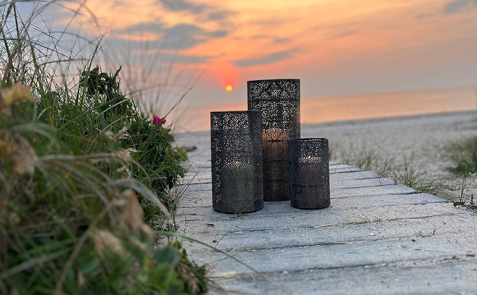 Sunset at the beach with the set of 3 candle lanterns upon the sandy boardwalk