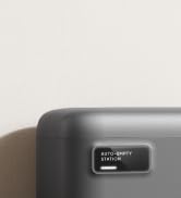Nahaufnahme einer grauen Ecke eines elektronischen Geräts mit einem kleinen rechteckigen Display, auf dem der Text „STILL-SPOT“ angezeigt wird. Das Gerät hat eine glatte, matte Oberfläche