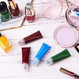 Assortment of cosmetics on white surface: nail polishes, makeup brushes, colorful tubes of product, and a circular compact powder.