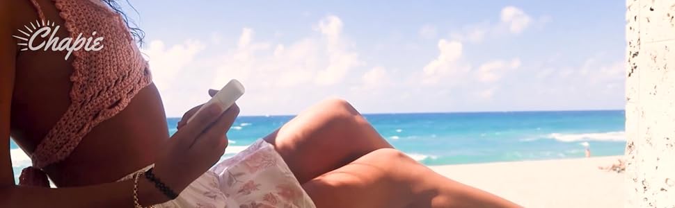 a girl by the beach holding a chapie with lip balm inside