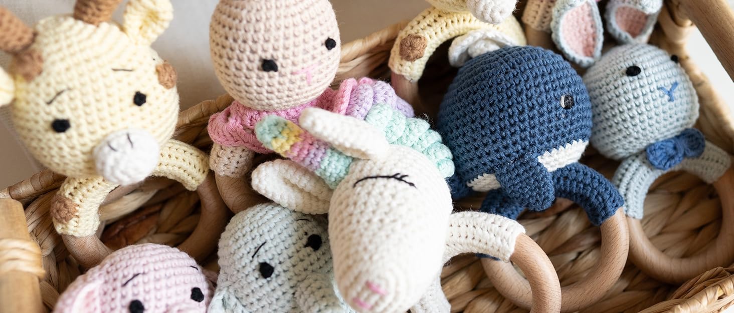 Crochet Animal Rattlers, like whales, Unicorns, Elephants, etc.  and Bunny family dolls on display.