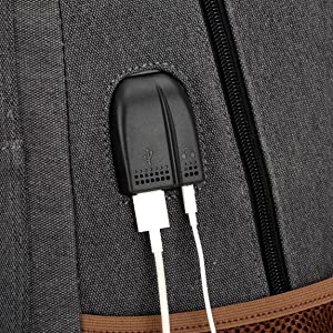 Gros plan d'une surface en tissu noir dotée d'une fermeture éclair et d'un port de chargement USB intégré, faisant probablement partie d'un sac ou d'un vêtement technologique