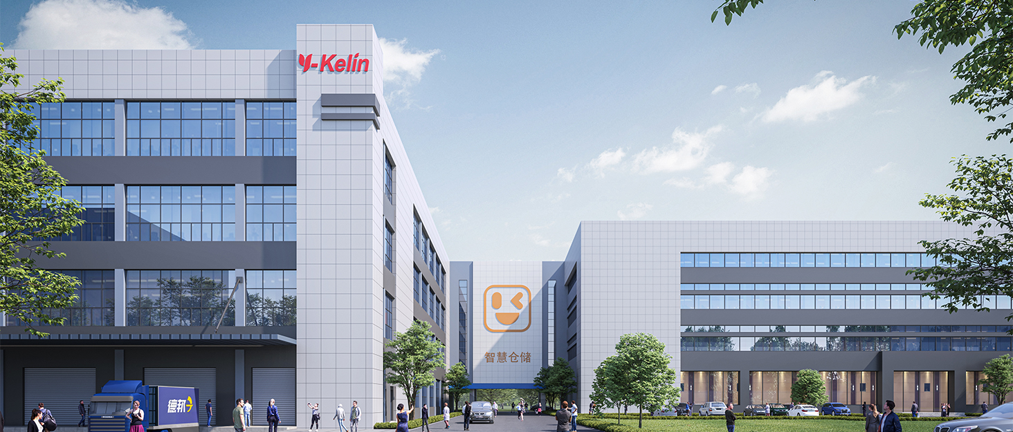 Modern office complex with glass facades and K-Kaifa logo. Multiple buildings connected by walkways, surrounded by trees and parking area. People walking near entrance.