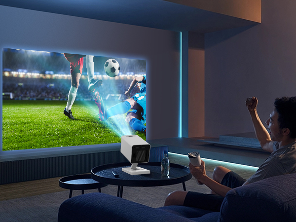 Home theater setup with large projected image of soccer match. Person sitting on couch, watching and cheering in a dimly lit room.