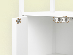 Nahaufnahme einer weißen Schrankecke mit Metallbefestigungsteilen und am Rahmen befestigten Scharnieren