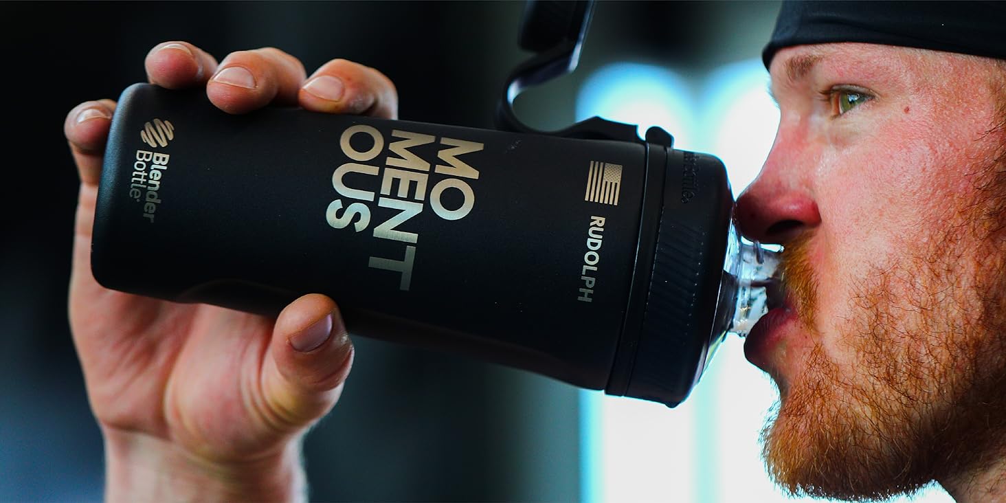 man with beard drinks from momentous water bottle