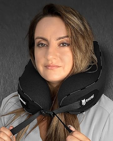 Black travel neck pillow with adjustable closure, shown wrapped around neck against dark background.