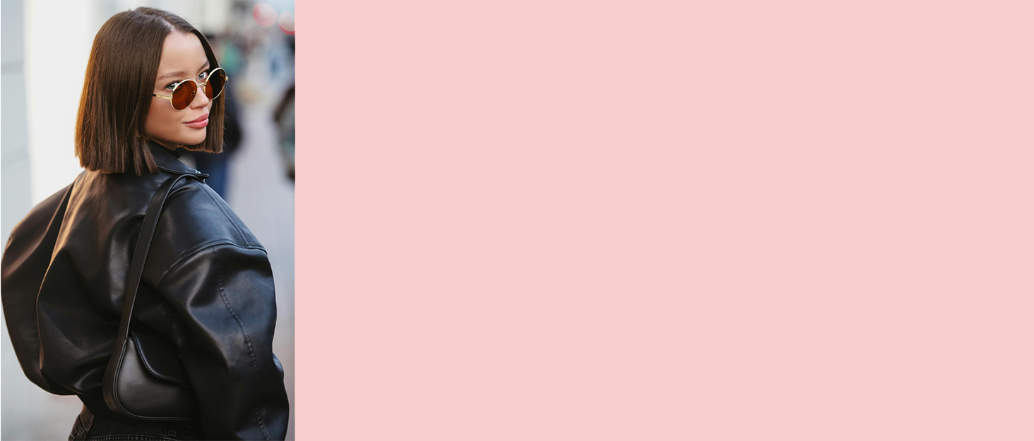 Stylish oversized black leather jacket worn by a person with brown hair. Large collar and loose fit visible from side profile view.