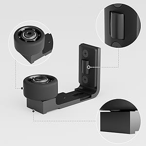 Black L-shaped camera mount with adjustable components. Features circular lens housing, pivot joint, and mounting plate with screw holes for versatile attachment options.