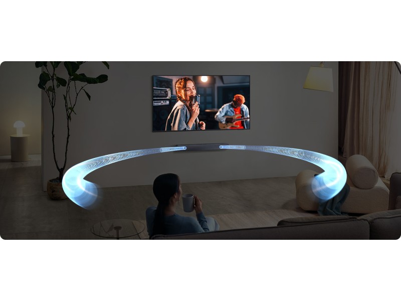 Curved soundbar or speaker device in light blue color, showing projected display on wall in home entertainment setting.