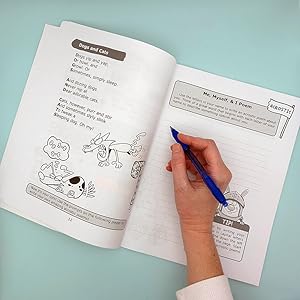 Open book with hand holding a pen.