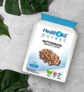 White pouch of HealthKart Activated Almonds displayed on white surface with green leaves. Package indicates raw, gluten-free, and vegan product.