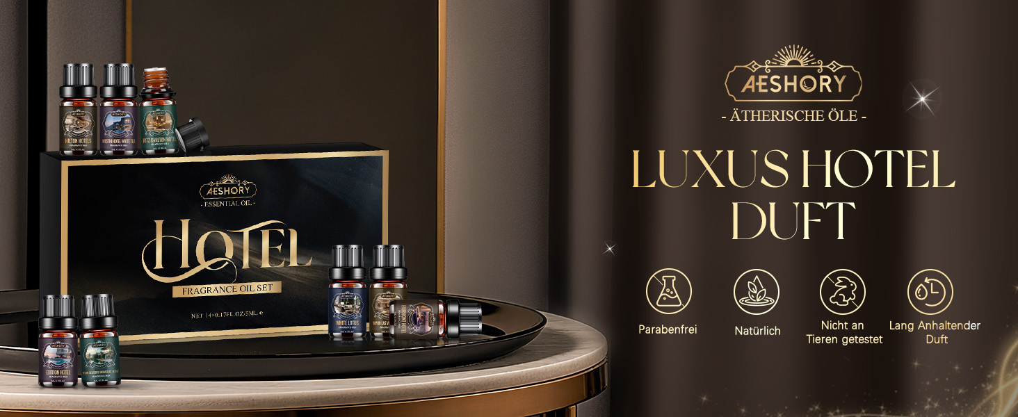 Der Text lautet: „LUXE HOTEL DUFT“ mit luxuriösem Produktdisplay mit schwarz-goldener Verpackung und mehreren Glasflaschen, die auf einer eleganten Oberfläche angeordnet sind.