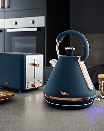 Navy blue electric kettle with copper-colored accents alongside matching toaster on dark kitchen counter. Both appliances feature modern, retro-inspired design elements.