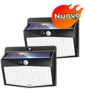 Dos luces solares exteriores negras con sensores de movimiento. Cada luz tiene un panel solar ancho y varios LED. En la imagen se ve una pegatina roja con la inscripción «Nuovo»