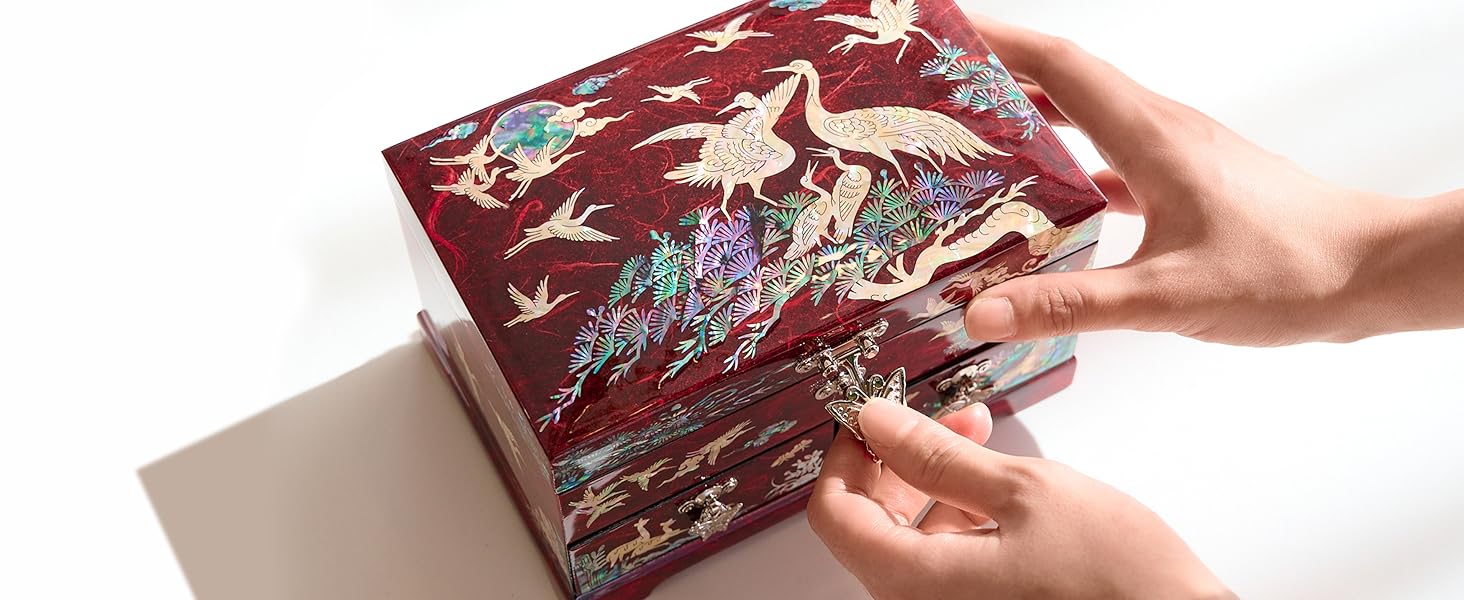 Cranes pine tree design mother of pearl close up image with hands