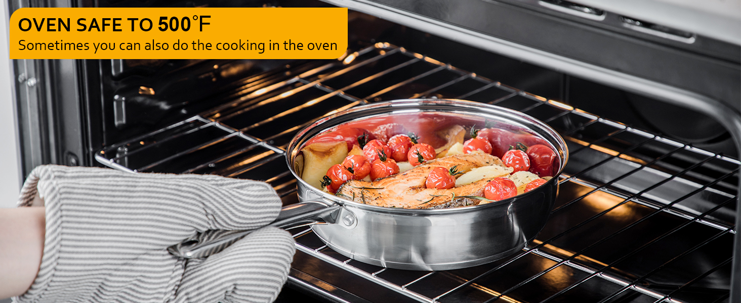 Oven-safe metal pan with food inside an open oven. Text overlay states 'OVEN SAFE TO 500°F'. Gloved hand holding pan handle.