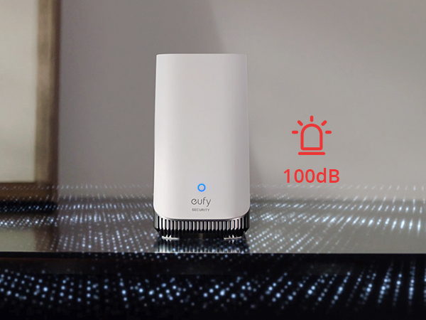 Cylindrical white smart device on reflective surface. Blue LED indicator light visible. Red icon showing 100dB sound level.