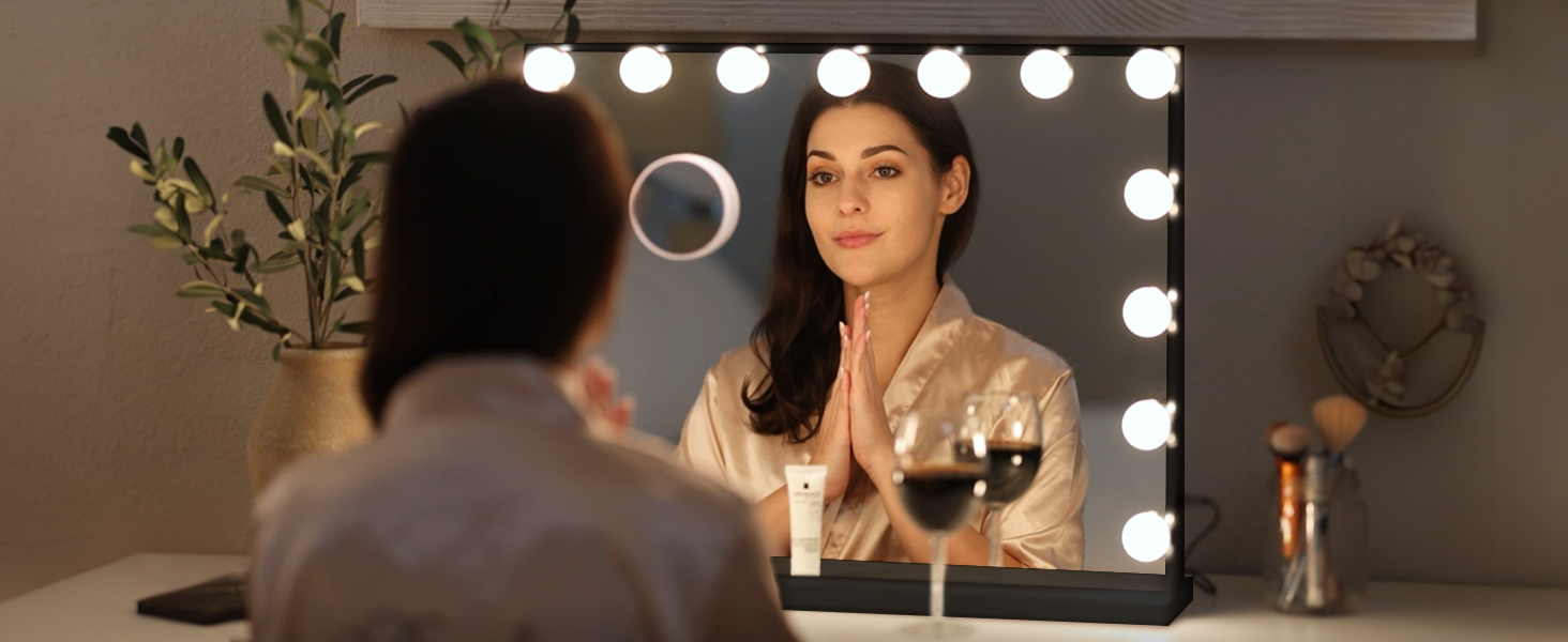 a woman in a bathrobe looks at her reflection in a mirror.
