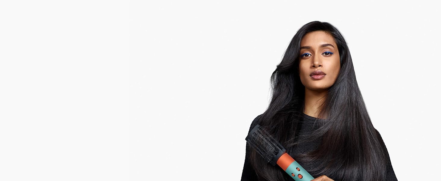 A model with long, dark hair uses the Firm smoothing brush to reduce frizz.