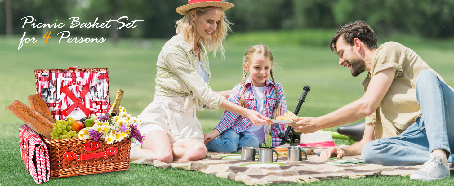 Family picnic scene with wicker basket, red and white checkered blanket, and assorted food items on grass in a park setting.