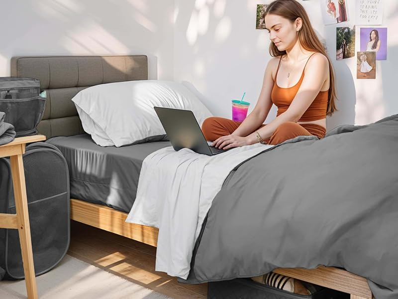 Girl sitting in room with dorm set arranged