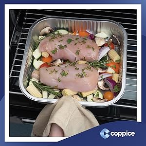 Foil tray with chicken and vegetables being placed in an oven