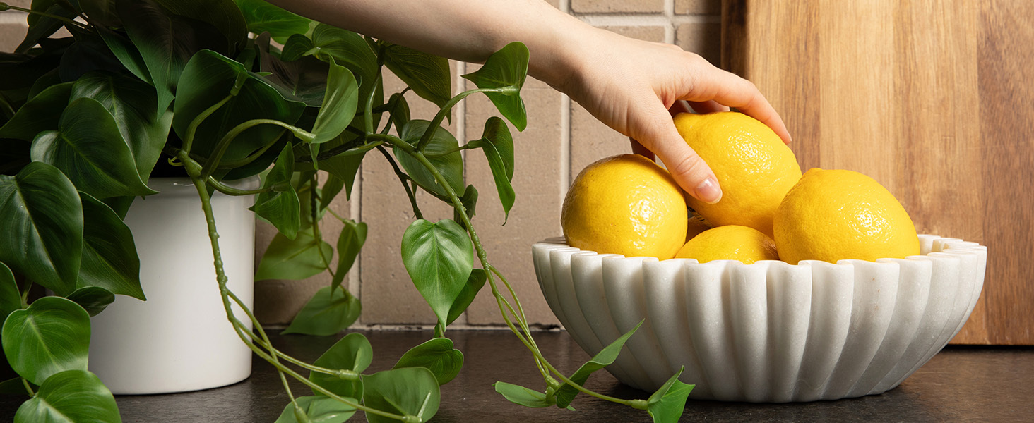 lemons being displayed in modern marble fruit bowl for kitchen counter