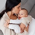 A mother lovingly holds and kisses her baby in a warm, comforting embrace