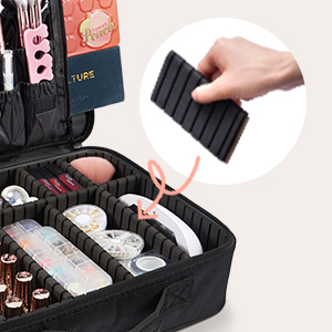 Makeup organizer case with adjustable dividers. Hand demonstrates inserting a black divider into the case, which contains various cosmetic products in organized compartments.