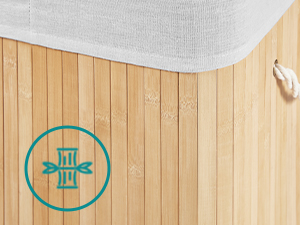 Close-up of a bamboo or wooden surface with vertical slats. A teal circular logo featuring geometric shapes is visible. Part of a white fabric or cover is seen at the top.