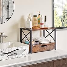 Organiseur de salle de bain de style industriel à deux niveaux avec étagères en bois et supports en X en métal noir, contenant divers articles de toilette et produits sur une surface de comptoir blanche