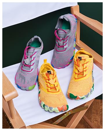 Tres zapatillas deportivas que se muestran en una superficie blanca, con combinaciones de colores gris, naranja y amarillo. Los zapatos tienen una parte superior de malla y un estilo deportivo con detalles de encaje en contraste.