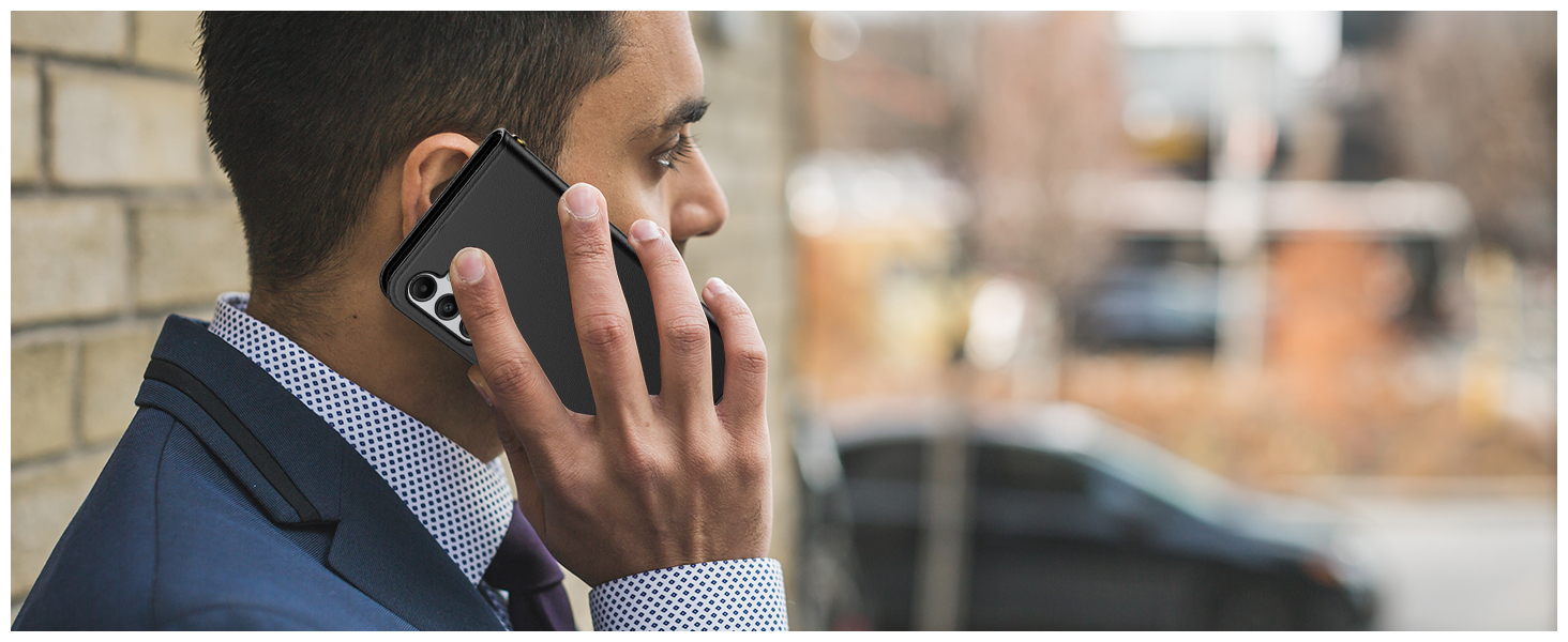 Close-up profile view of businessman in suit jacket speaking on mobile phone against brick wall background.