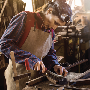 A welder prepares metal with tools for a welding project