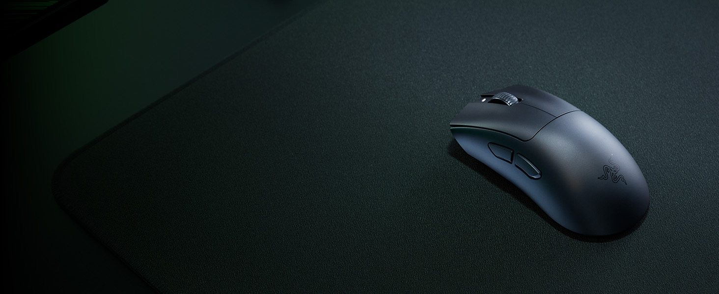 Souris d'ordinateur noire sur fond sombre, présentant un design ergonomique simple avec un minimum de détails.