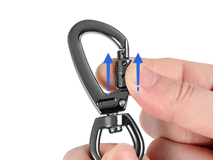 Close-up of a metal carabiner clip being opened by a finger, demonstrating its spring-loaded gate mechanism.